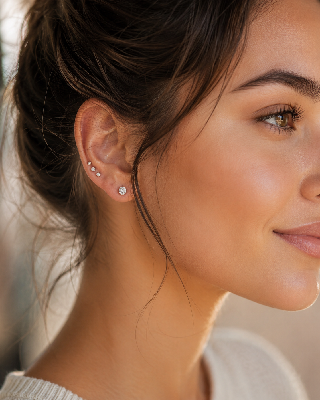 Close-up of a woman wearing diamond earrings with a blurred background