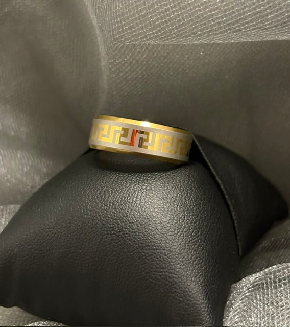 Gold ring with a geometric design on a textured gray surface