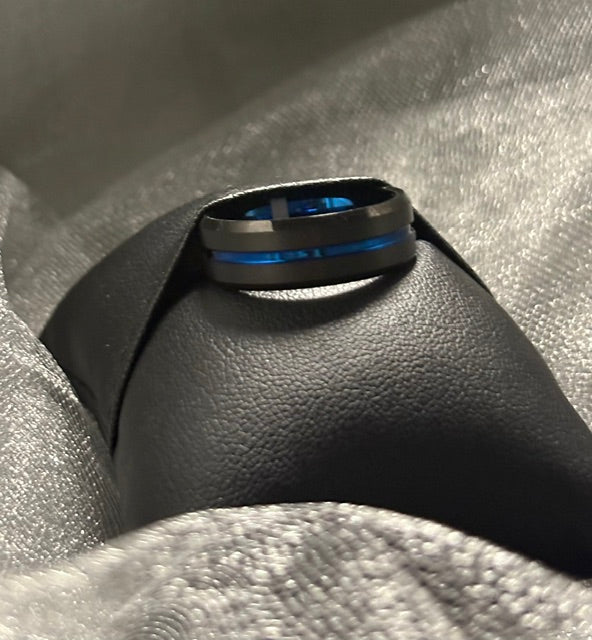 black and blue tungsten ring on a black pillow