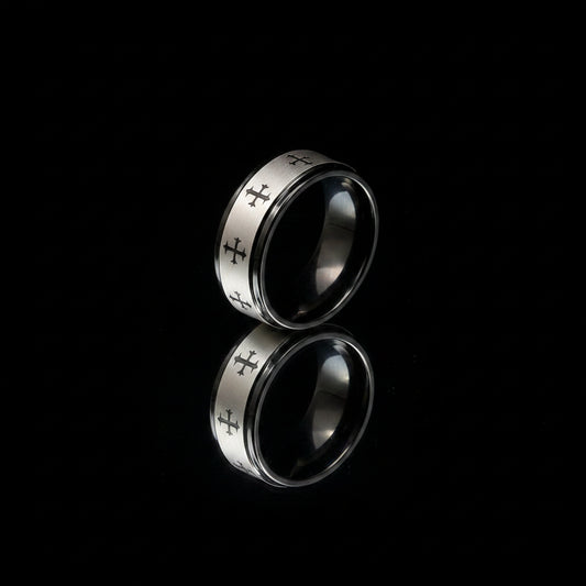 Silver ring with engraved designs on a textured gray surface