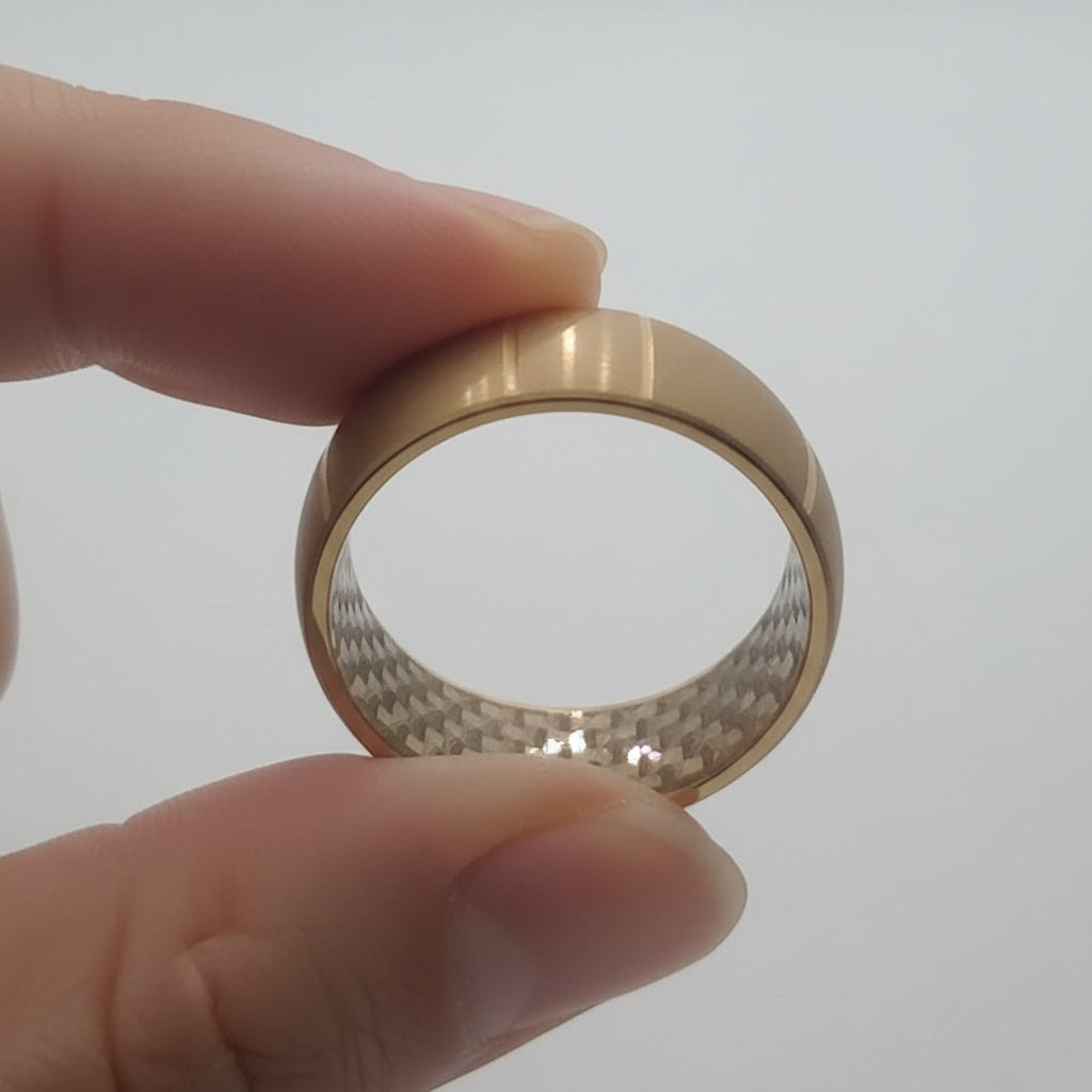 yellow gold tungsten ring held with two fingers, showing design on inside of ring