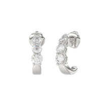 Pair of silver hoop earrings with clear gemstones on a white background